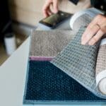 woman choosing fabrics swatches for sofa in store